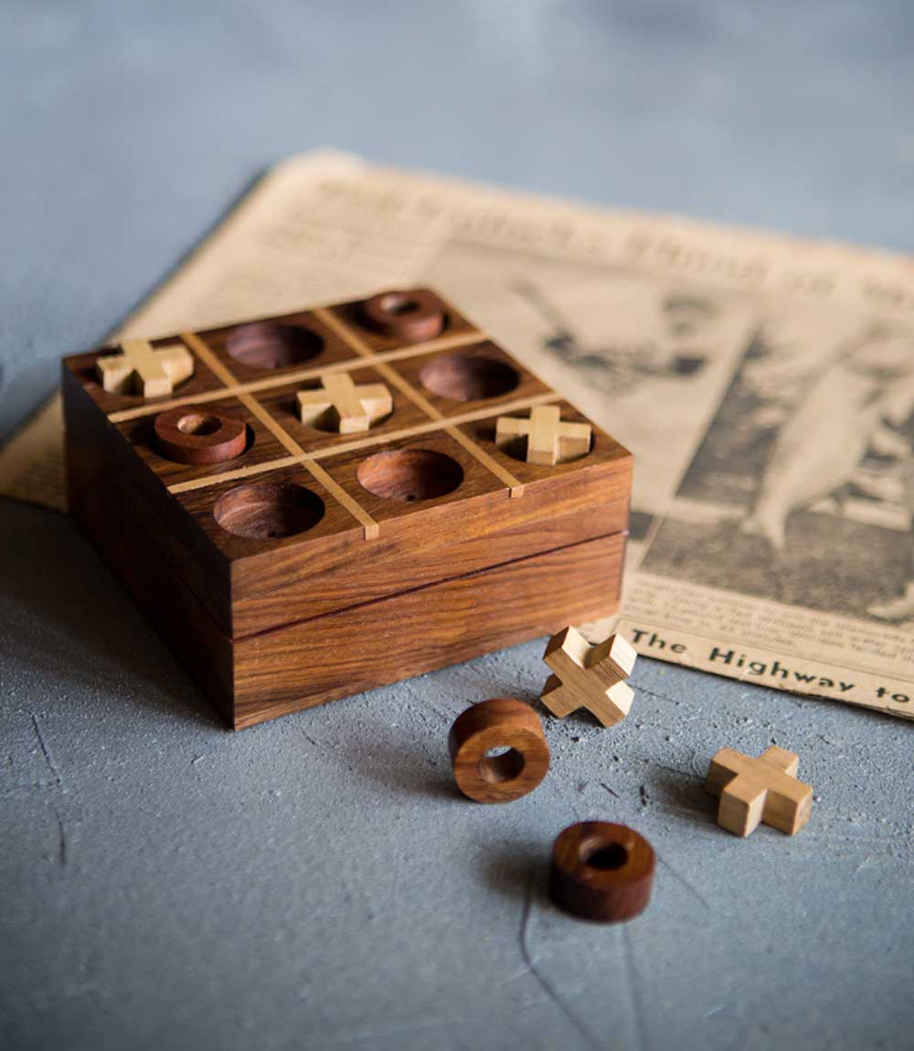 Handcrafted wooden tic-tac-toe board with carved X and O pieces and open case