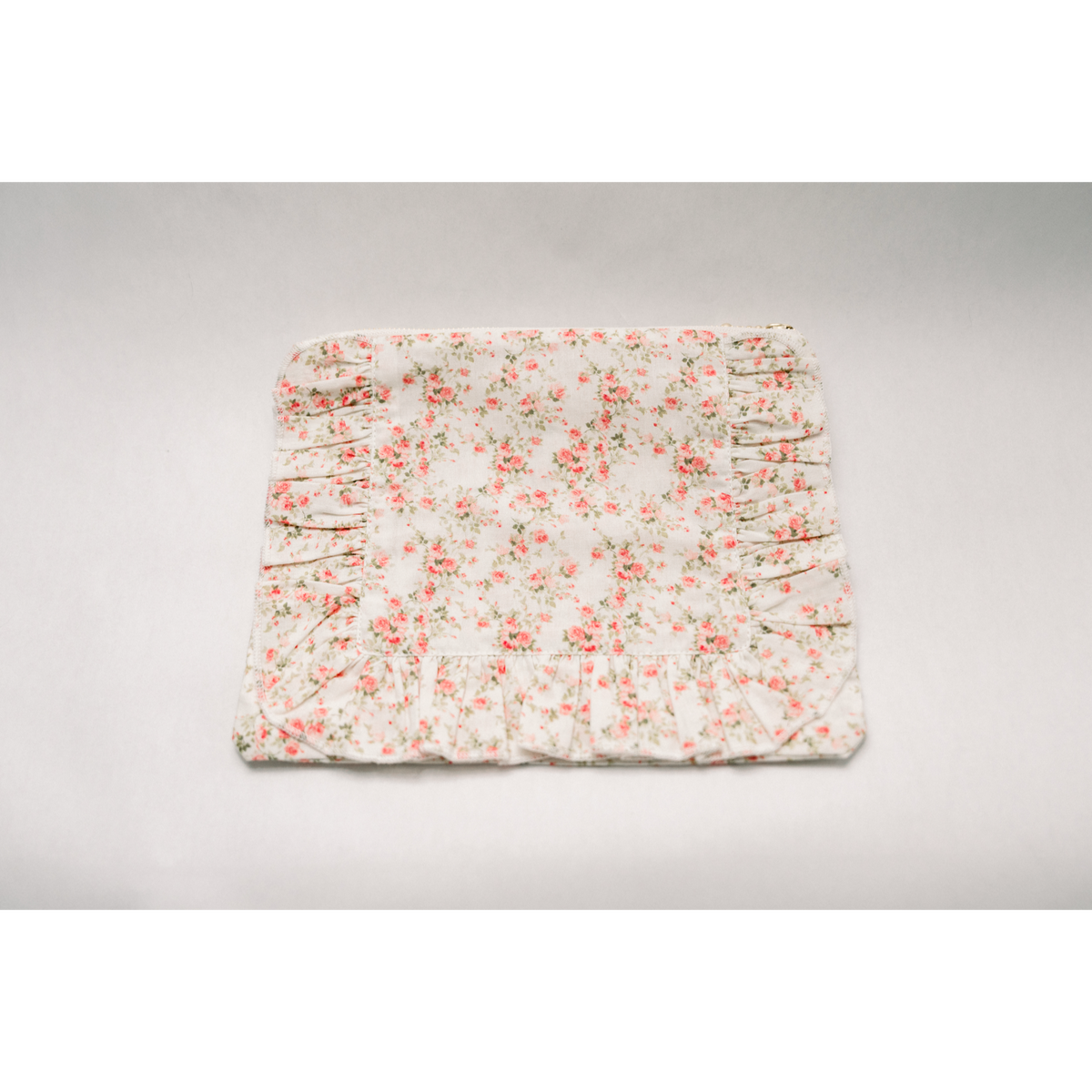 White floral ruffle zip pouch with ruched ruffle edge and stitched seam