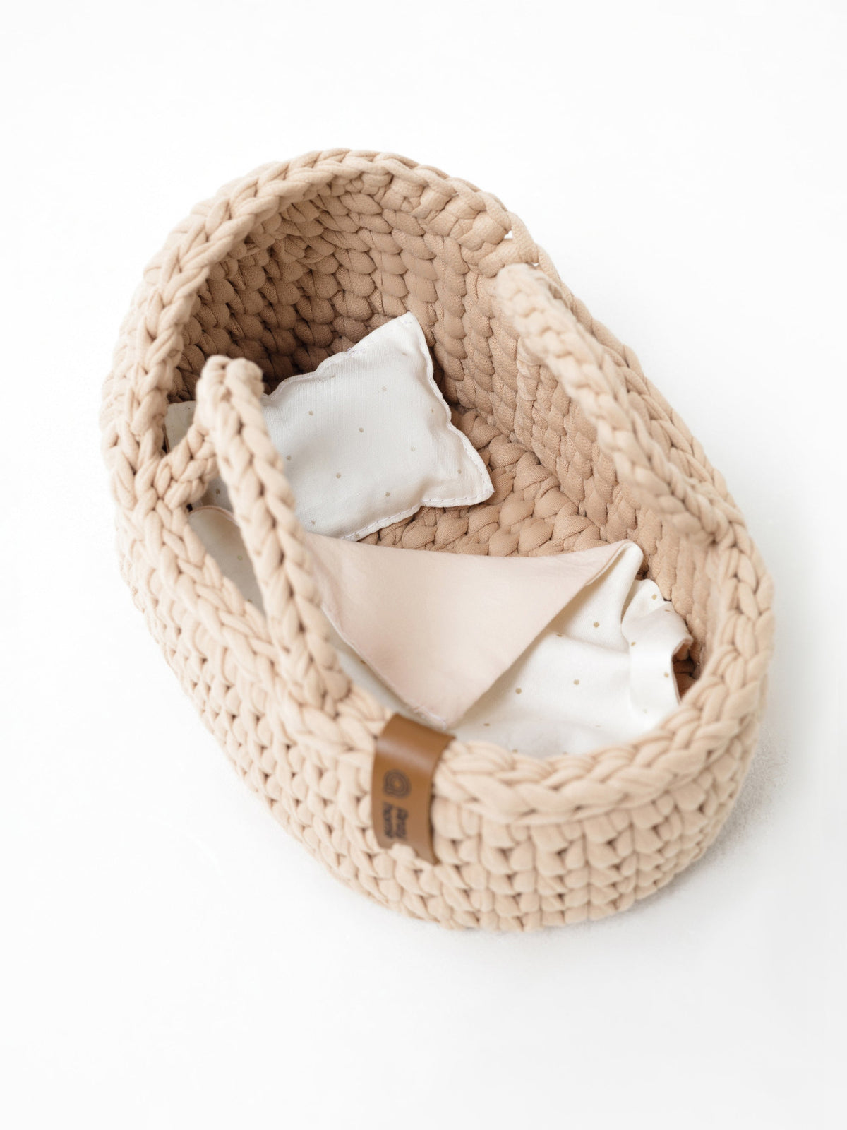 Beige woven mini moses basket with handle, interior cushions and pillow