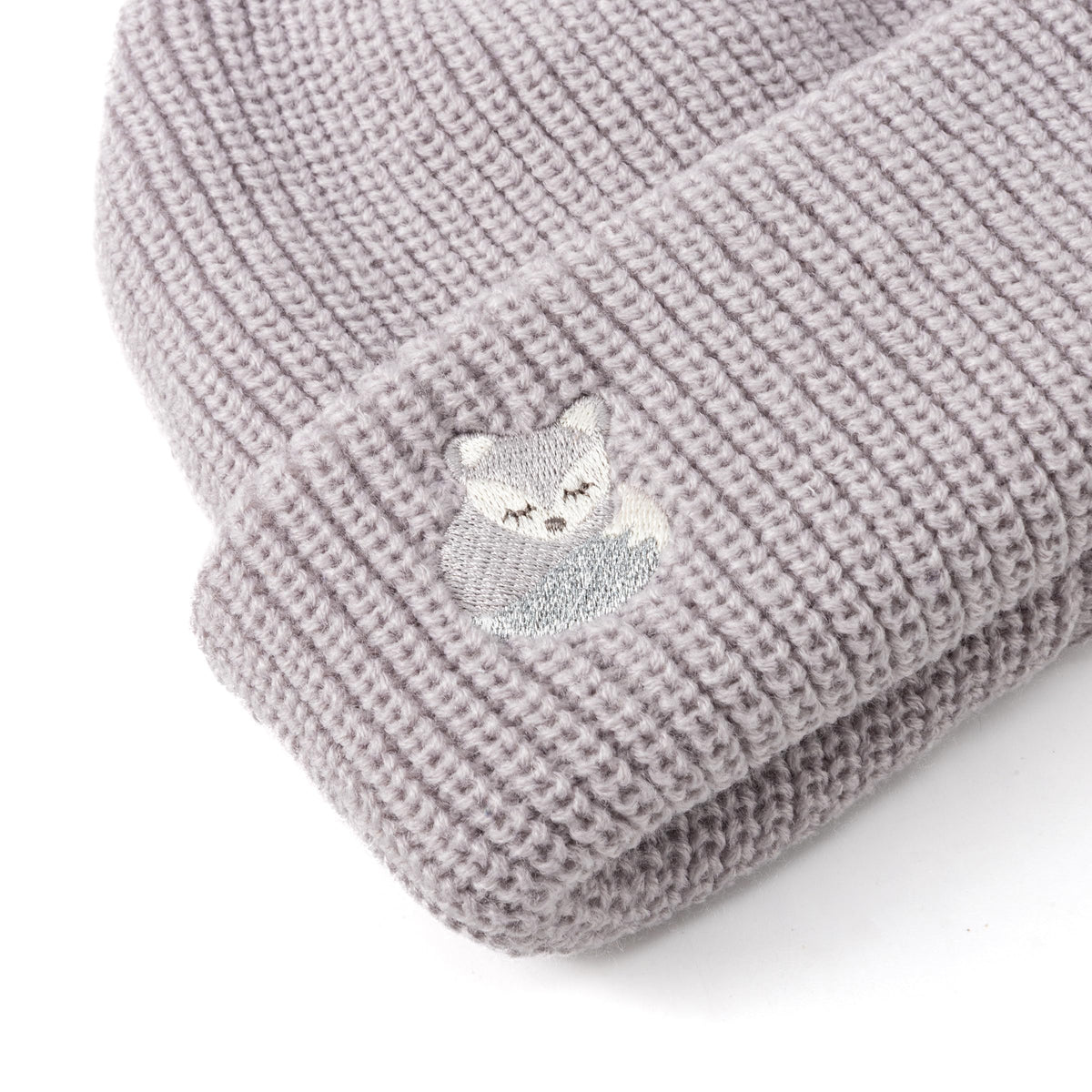 Close-up of gray beanie cuff with fox embroidery and silver thread detail
