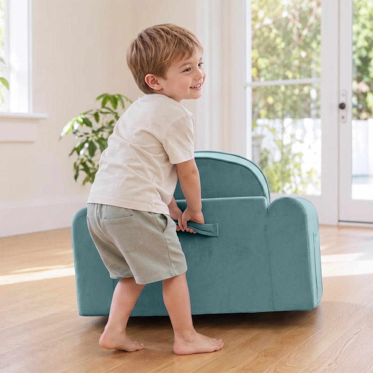 Tiny Land® teal kids sofa chair with a child holding its side handle
