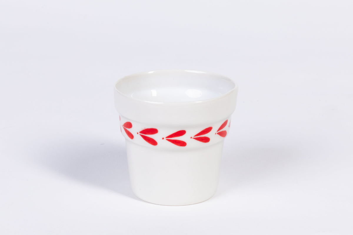 White ceramic espresso cup with red leaf band and glossy top