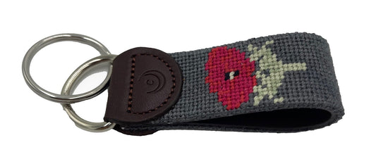 Hand-stitched needlepoint key fob with red poppy on charcoal fabric and leather strap