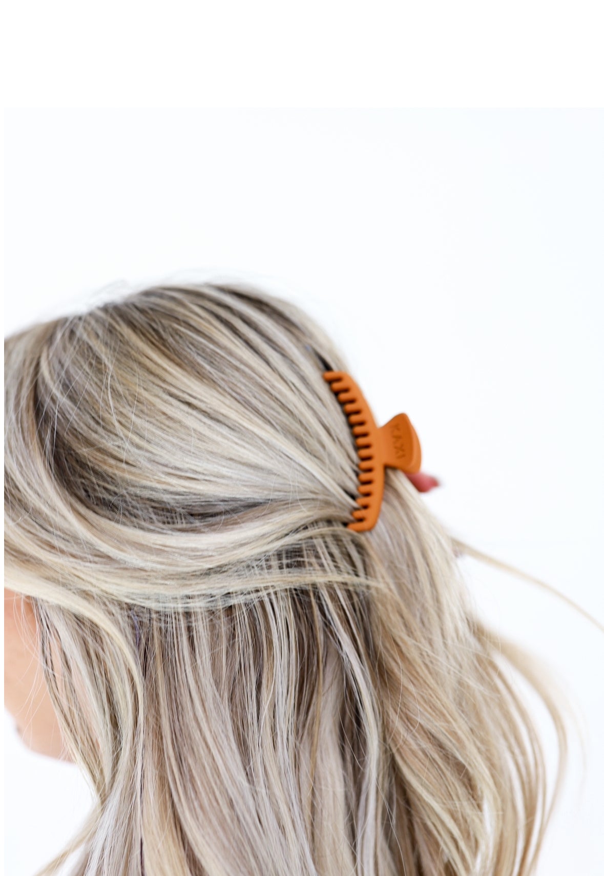 Matte mini hold-everything claw hair clip on blonde hair, orange accent near scalp