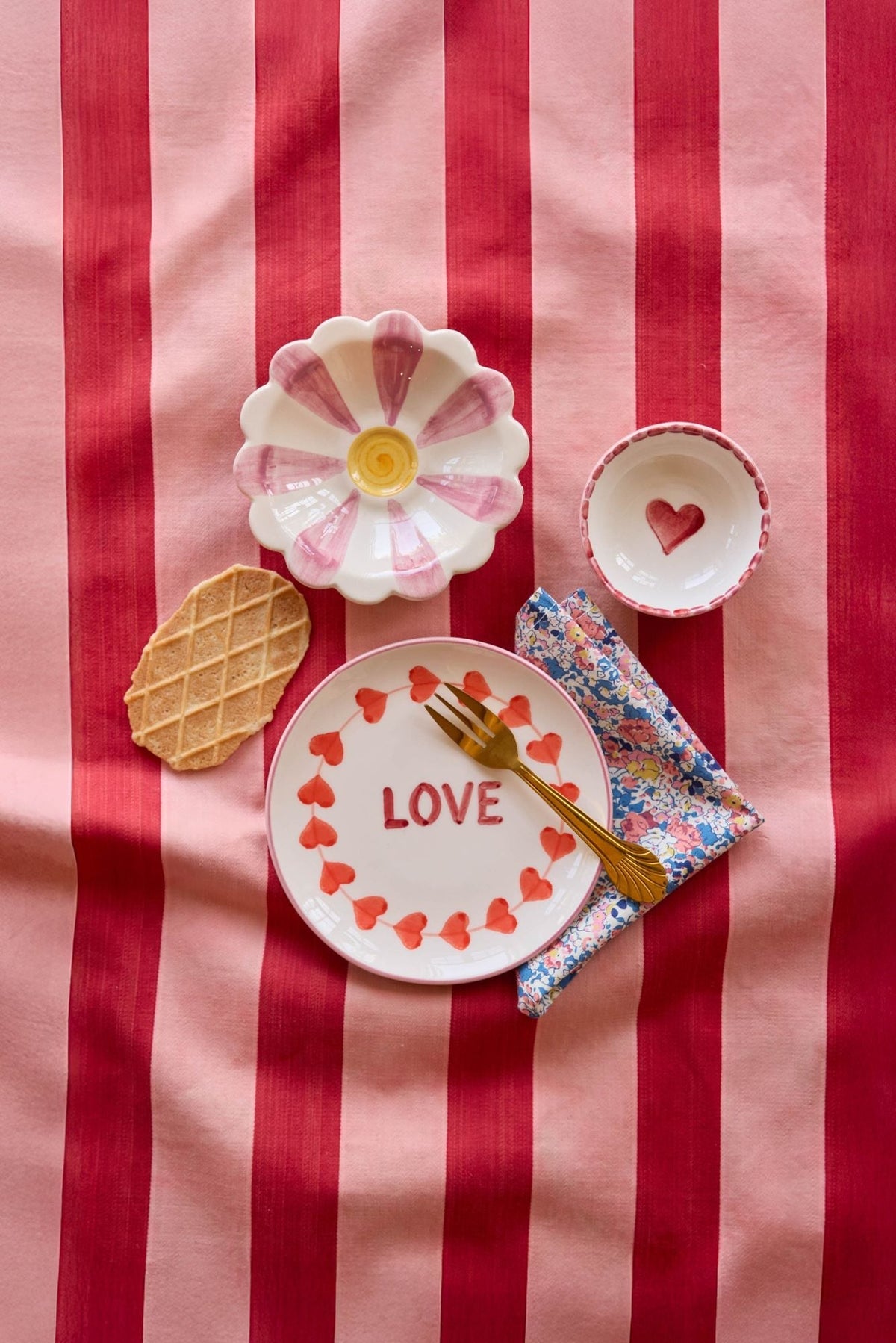 Small ceramic dipping bowl with red heart on white interior and scalloped rim