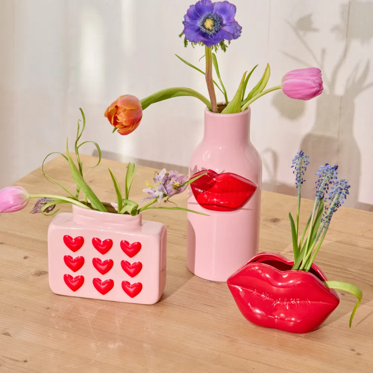 Pink ceramic vase with embossed red hearts on front, square shape and short neck