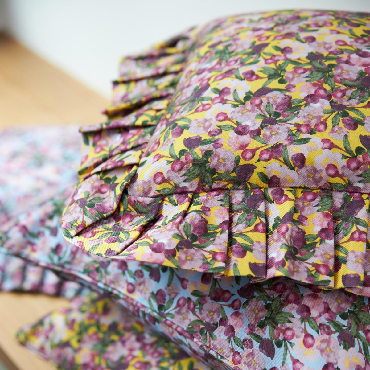 Side view of yellow floral ruffled pillow cover with gathered ruffle trim