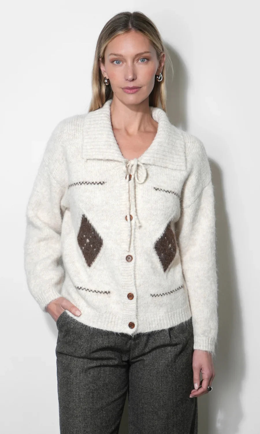 Cream knit cardigan front view with drawstring tie, button closure, and brown diamond patches.