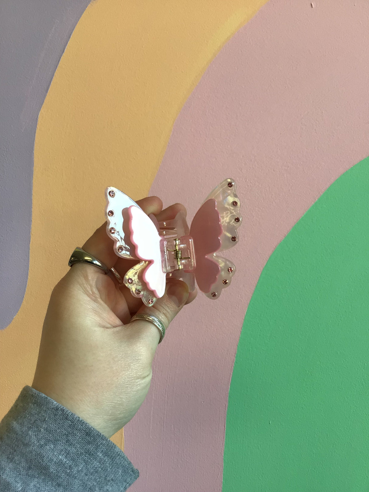 Butterfly hair claw with pink-and-white wings, jeweled edge, and silver comb clip