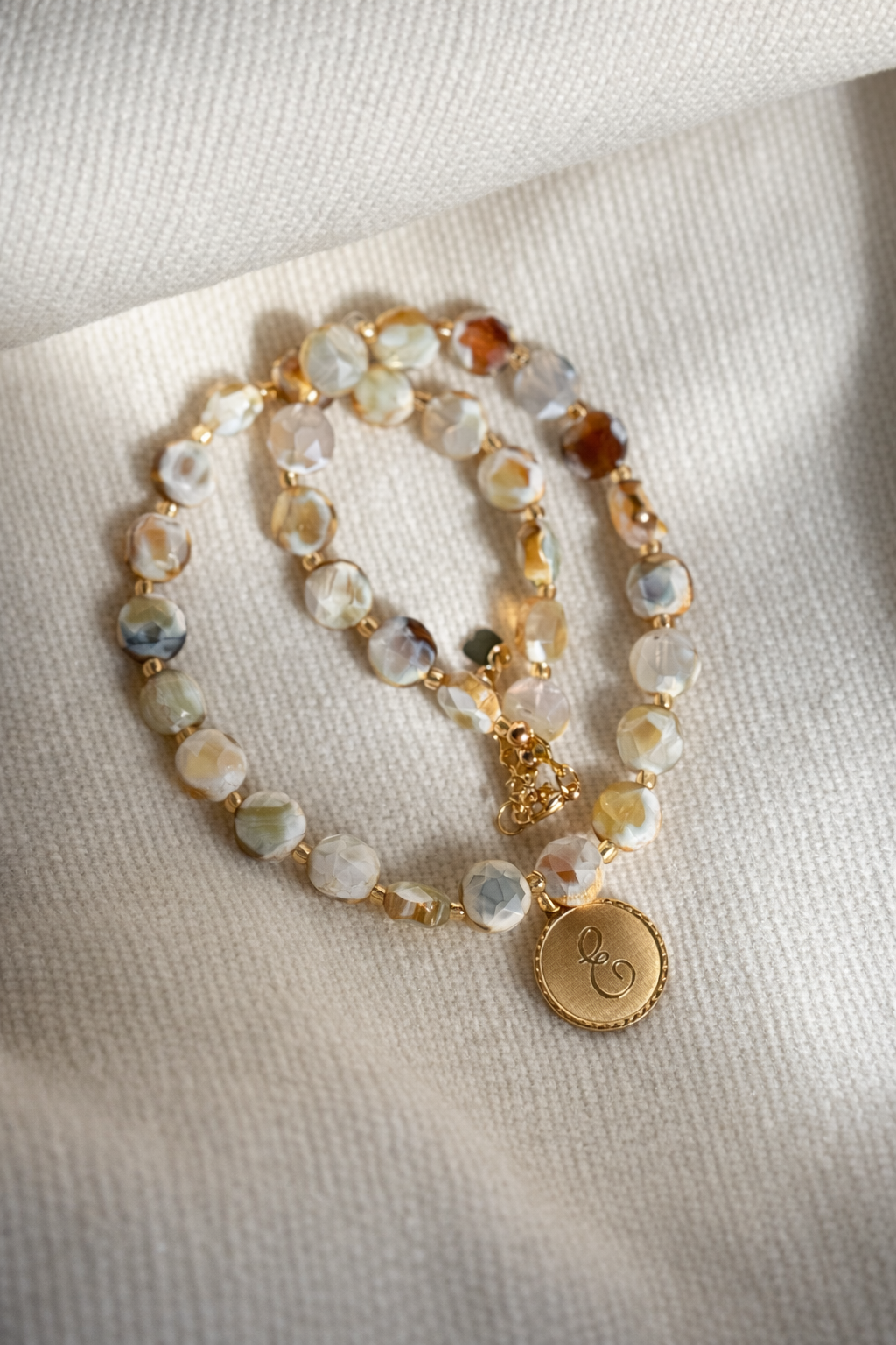 Agate beaded necklace with round gold initial pendant and multicolor bead strands