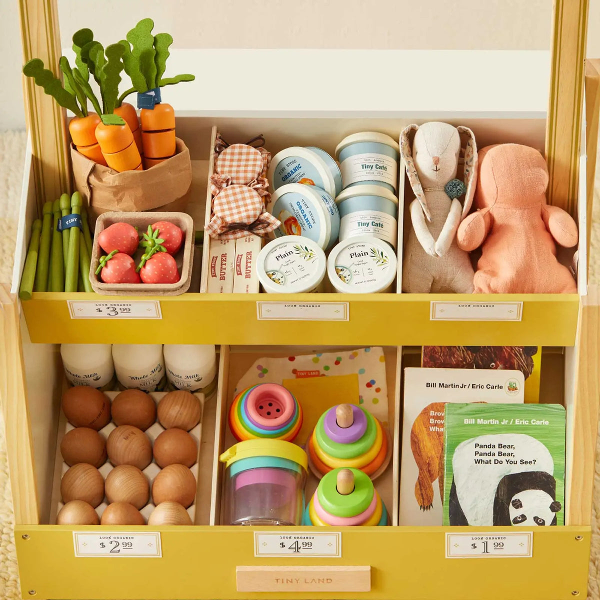 Grocery store playset shelves stocked with toy produce, groceries, eggs, toys, and books.