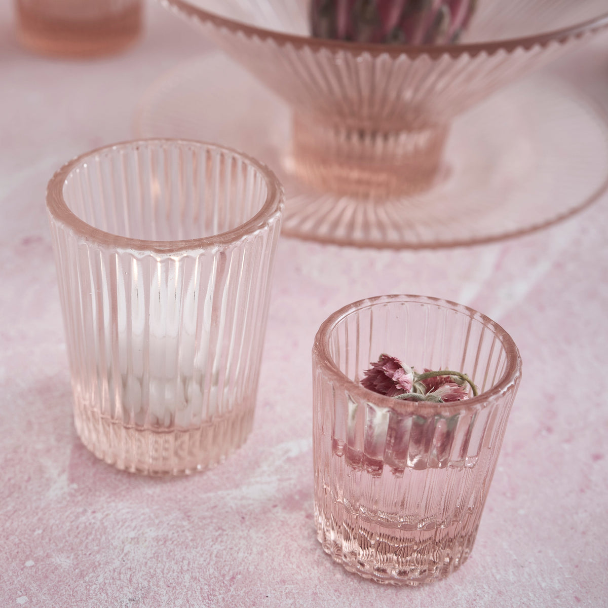 Pink pressed juice glasses, two ribbed tumblers with floral garnish inside
