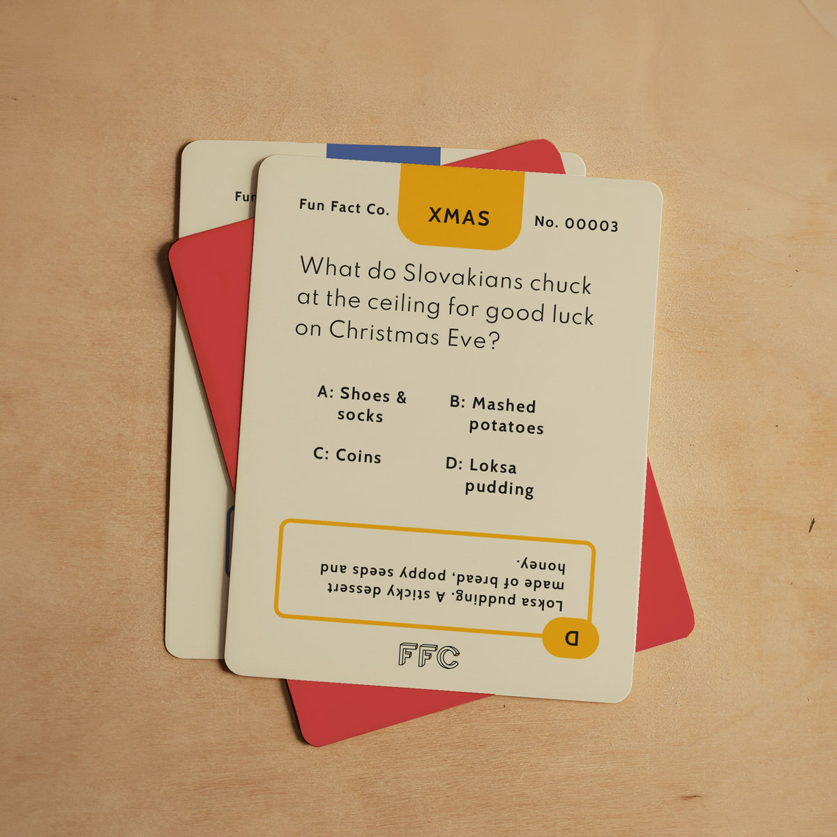 Christmas trivia question cards stacked with XMAS header and answer choices
