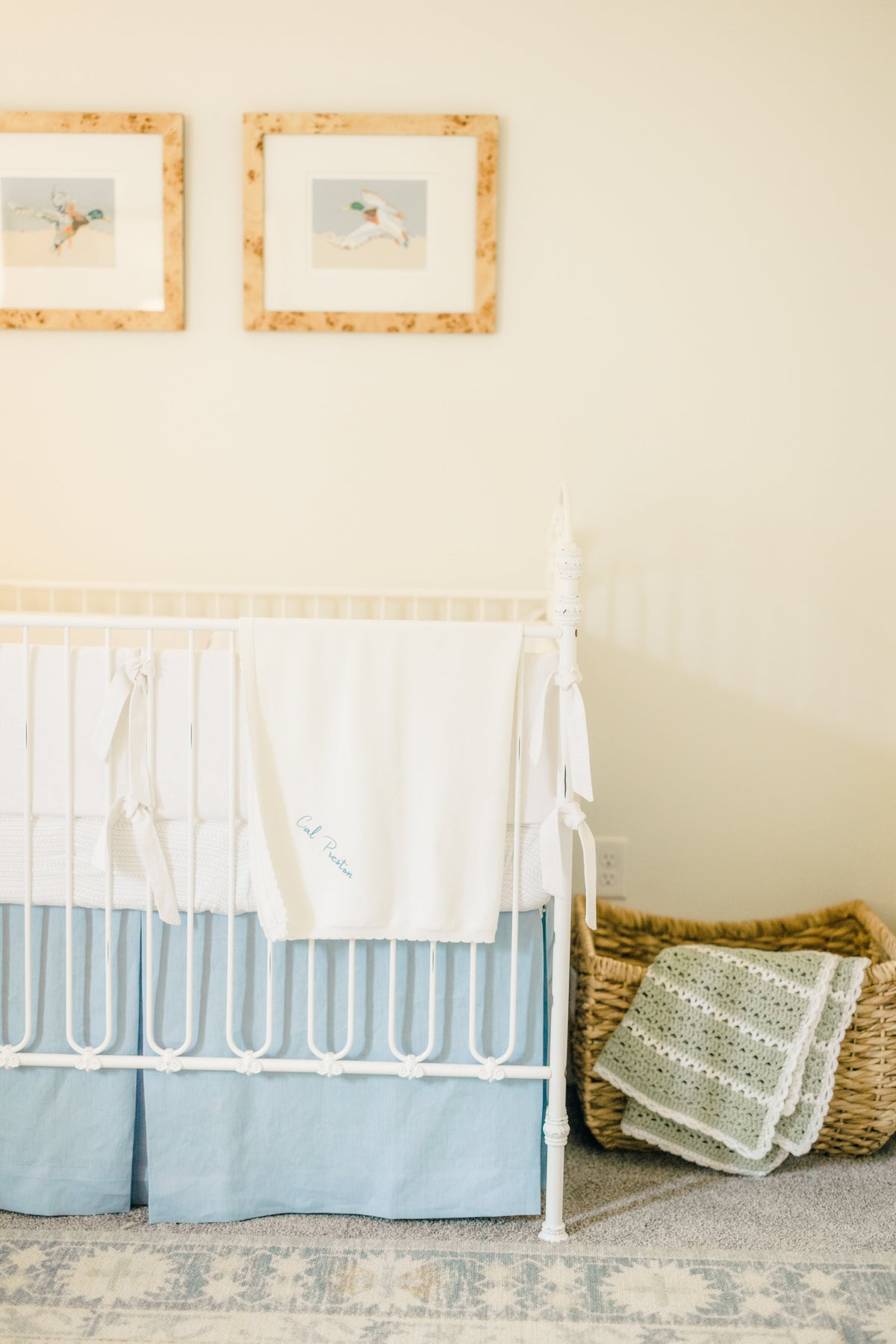 Nursery wall with two framed mallard duck flight prints above a white baby crib