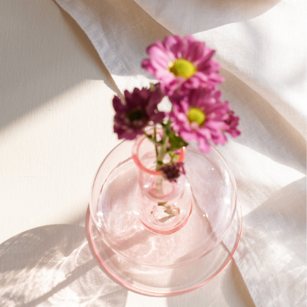 Siri pink glass candle holder holding a small bouquet of pink flowers