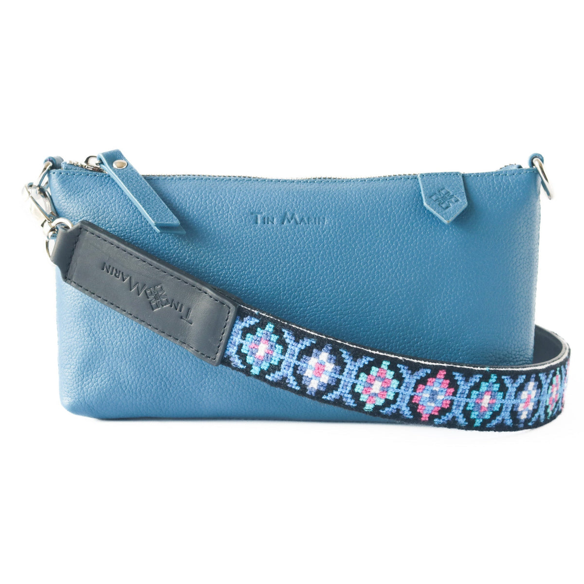 Woven bag strap with blue and pink geometric pattern and dark leather keeper
