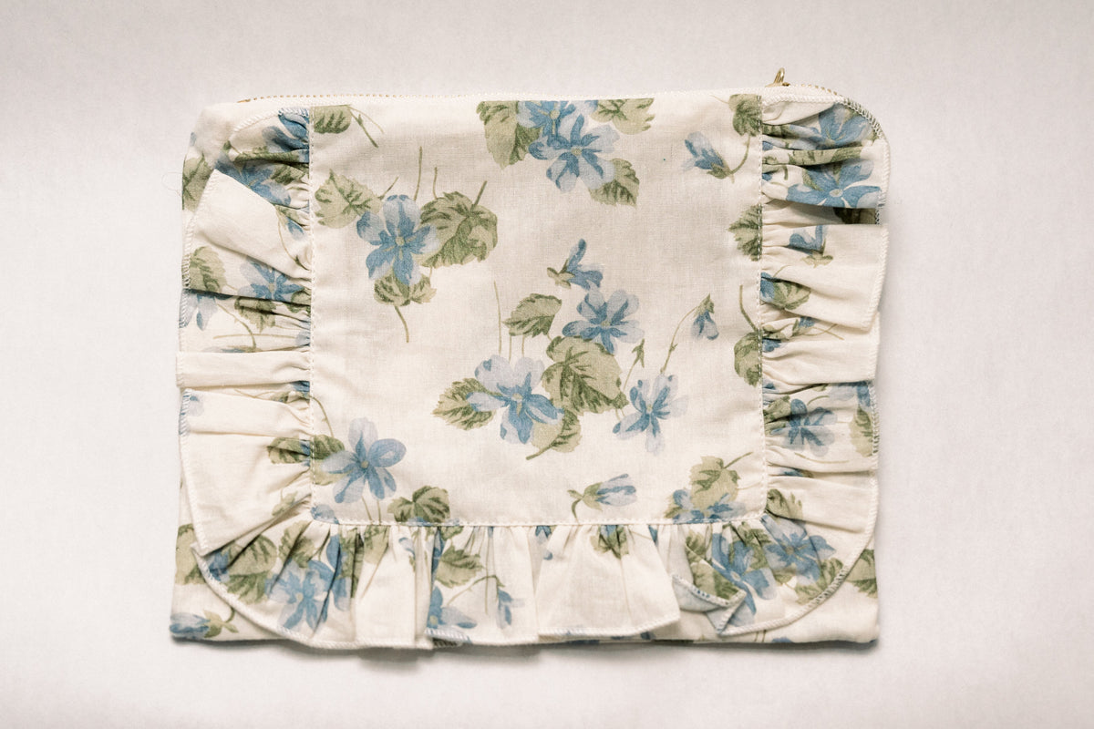 Floral ruffle zipper pouch in cream with blue and green botanical print, gathered sides