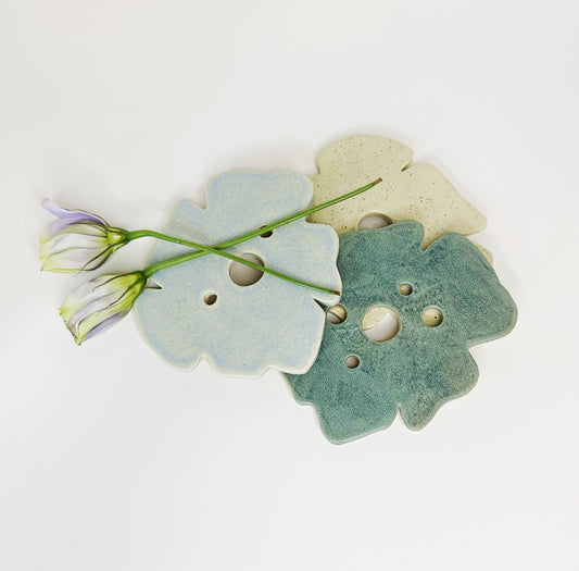 Pair of frog-shaped decor pieces in pastel blue and teal, with round holes