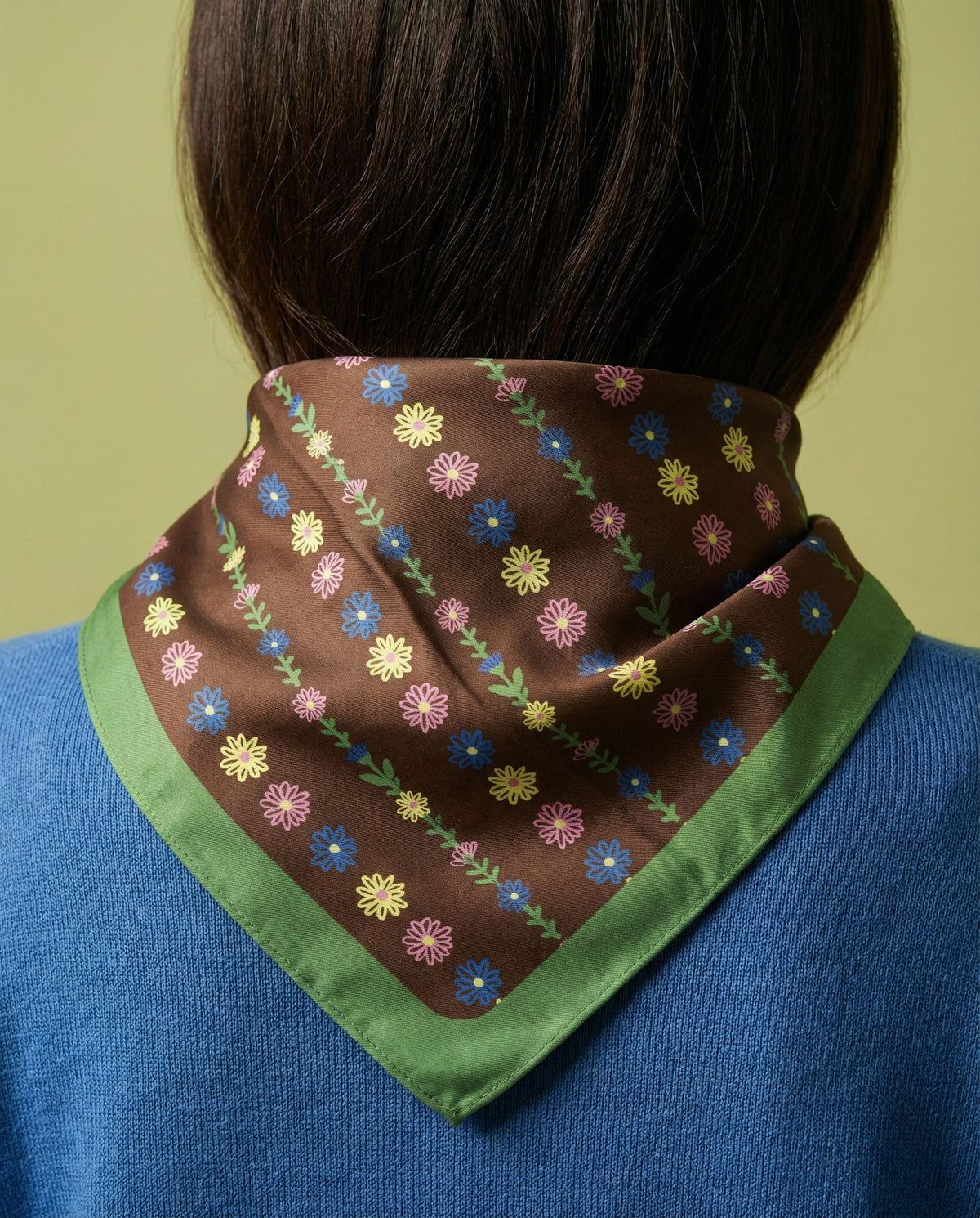 Multicolor tiny flower bandana with green border worn at neck