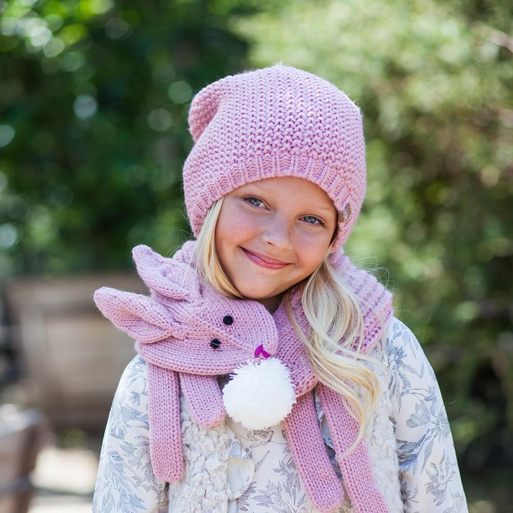 Pink knitted bunny scarf with long ends and a white pom-pom, worn with a matching hat
