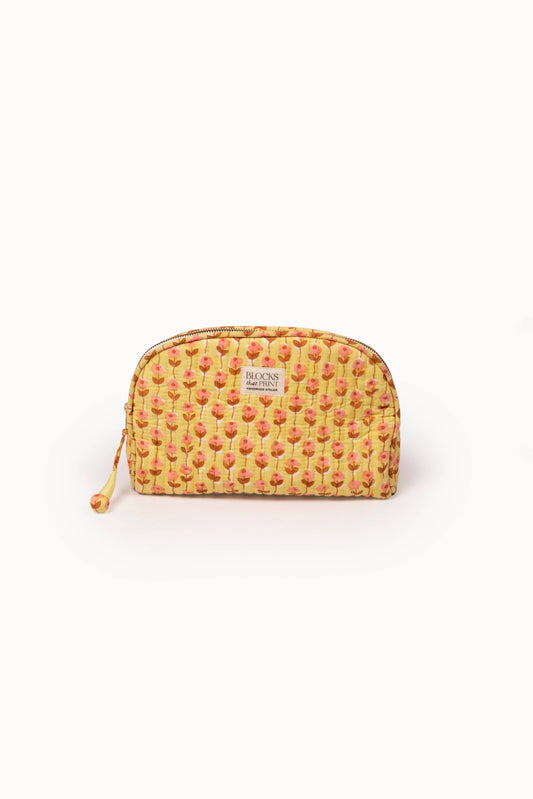 Quilted medium travel pouch with sunwashed floral print, zip top, orange cord pull.