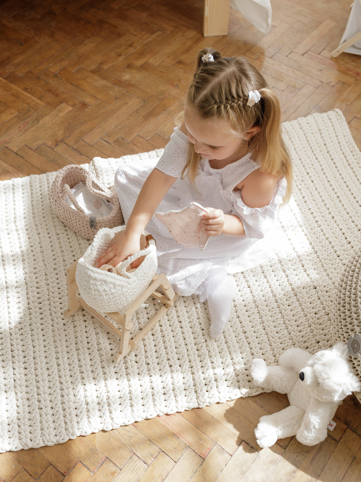 Mini doll moses basket with woven handle, open top, and doll accessory