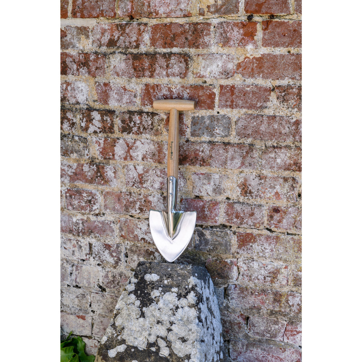 Small spade shovel with narrow stainless-steel blade and wooden handle