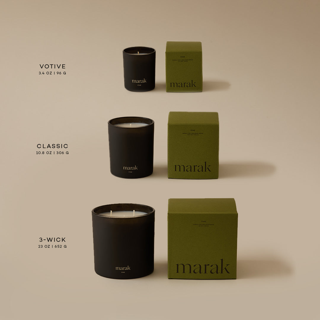 Candle trio with dark jars, white wicks, and green pine scent boxes