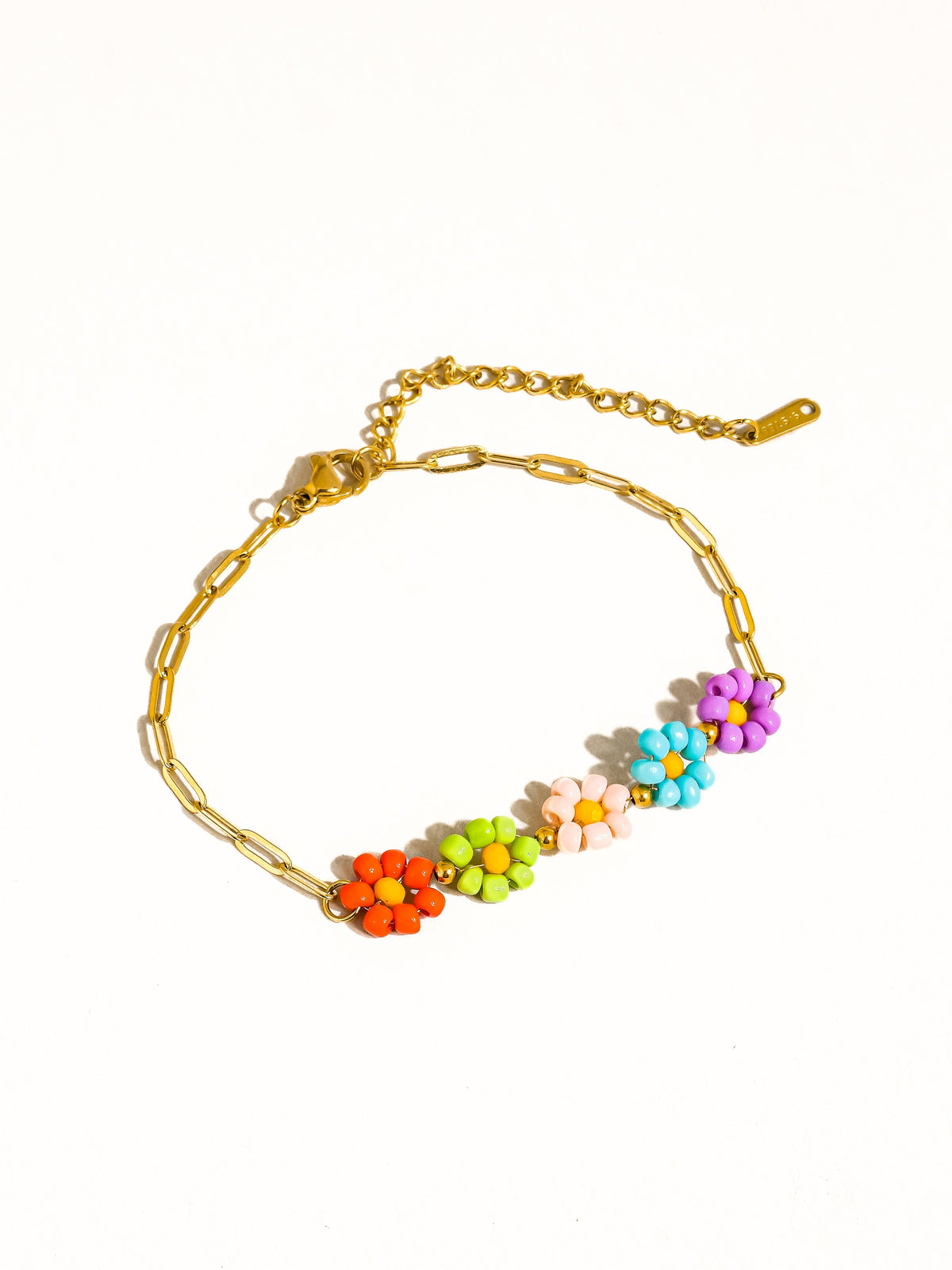 Gold-tone chain bracelet with colorful beaded daisy flowers and an adjustable extender.