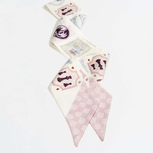 Silk twilly scarf with cream base, pink check pattern, and playing-card illustrations