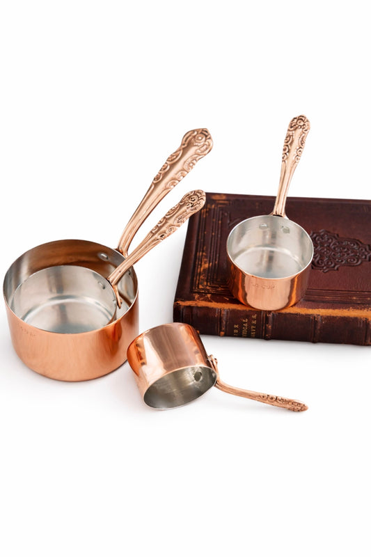Set of 4 vintage-inspired copper measuring cups with ornate handles and metal bowls