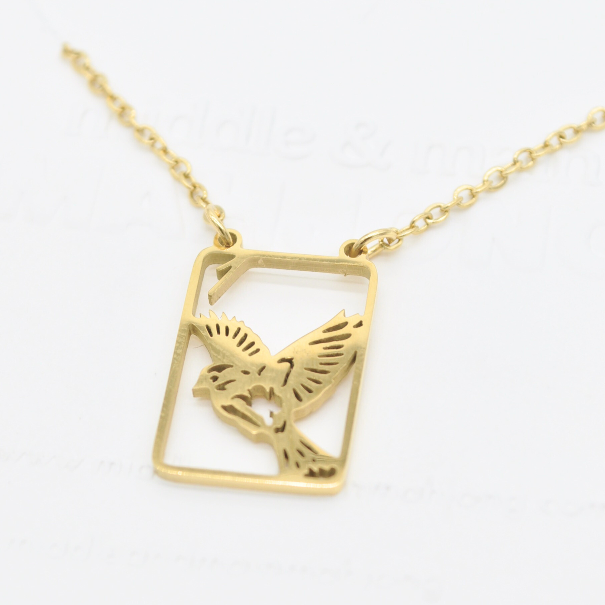 Gold bird pendant necklace, square frame with sparrow silhouette detail