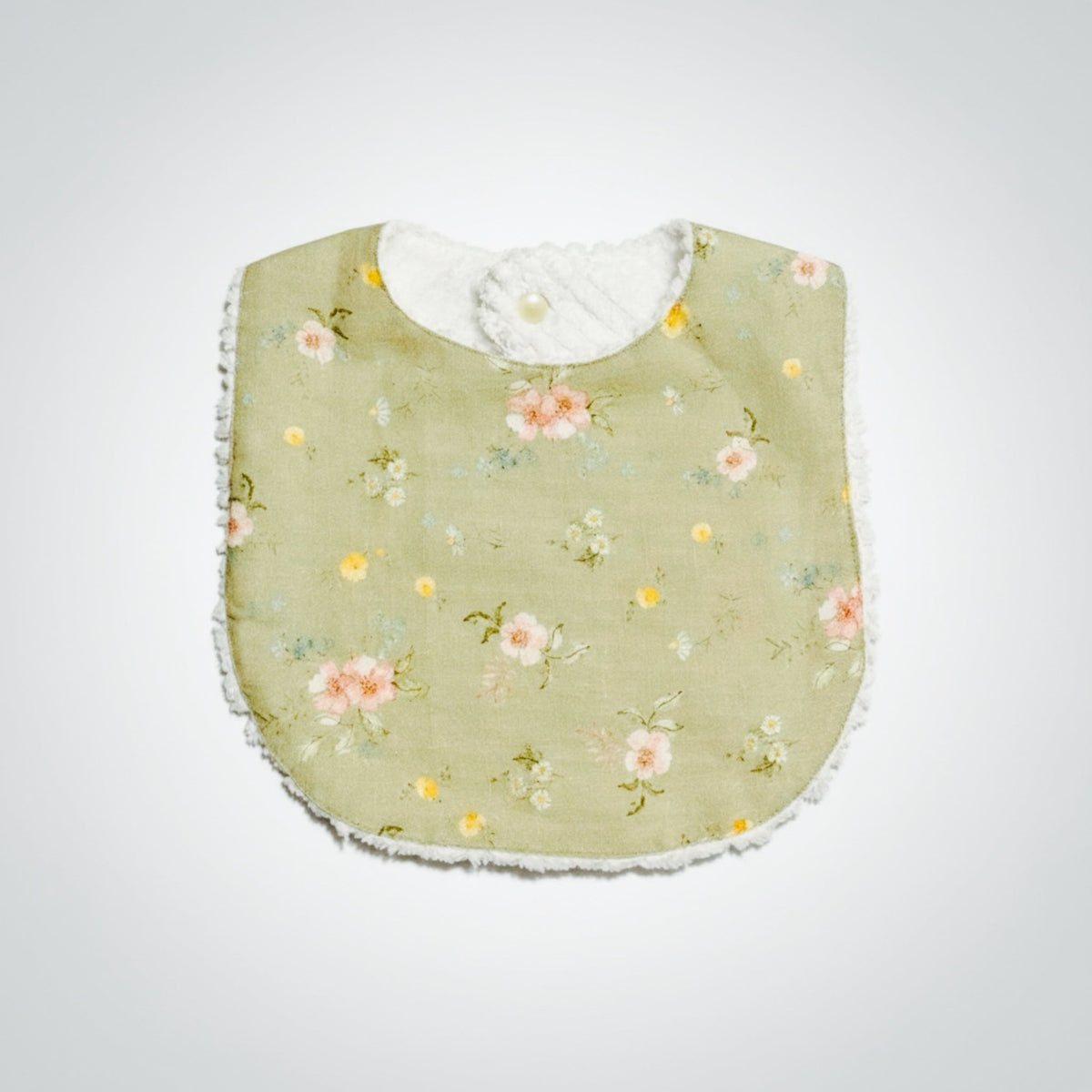 Infant linen bib in sage floral fabric with rounded neckline and snap-on closure