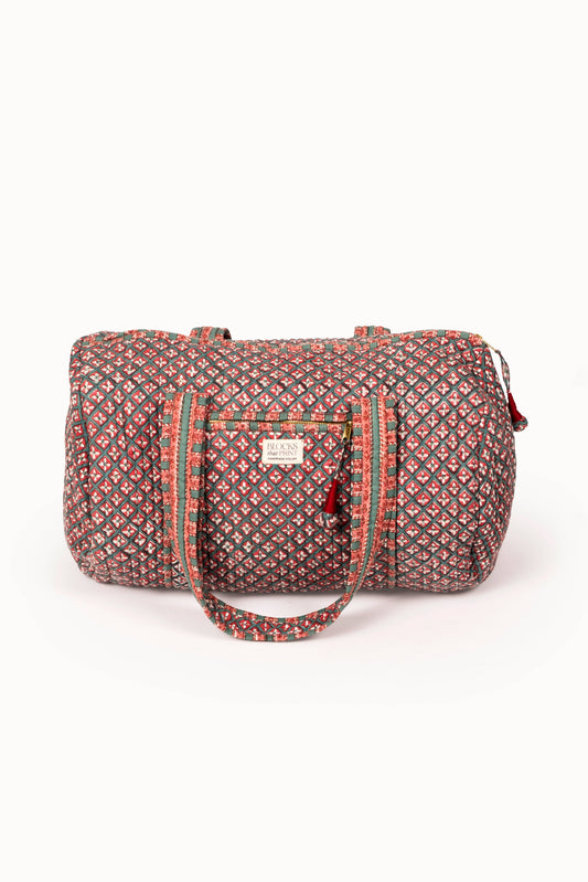 Quilted duffle bag with red-and-green block print, zip top, front pocket, strap