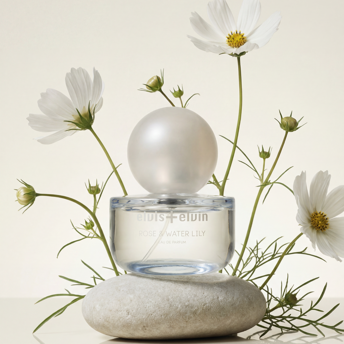Rose & Water Lily eau de parfum bottle on smooth stone with white flowers
