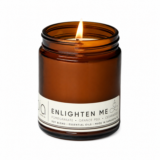 Amber glass jar soy blend candle with flame and white ENLIGHTEN ME label