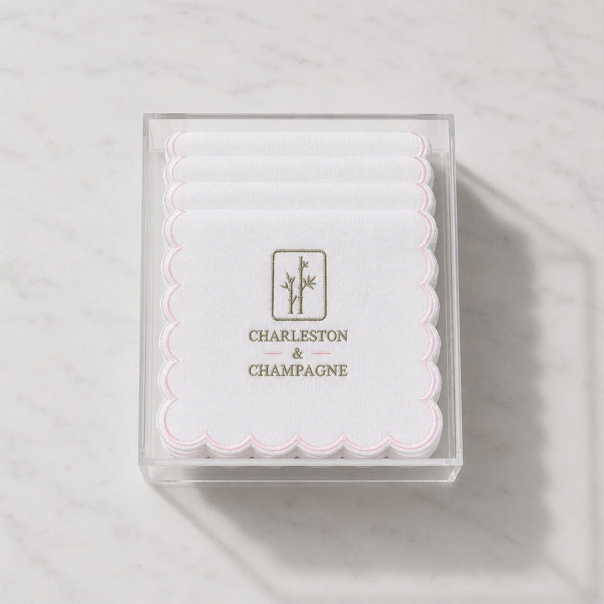 Embroidered cocktail napkin in clear box, pink scalloped edge with Charleston & Champagne