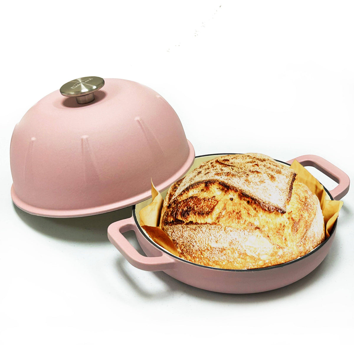 Pink cast iron bread cloche with dome lid, filled with baked loaf and handles