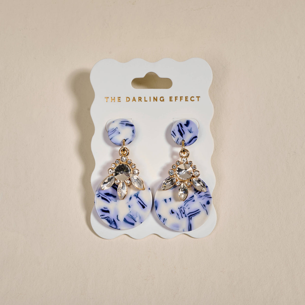 Earrings with blue-and-white drop shapes, crystal flower tops, and gold-tone leaves