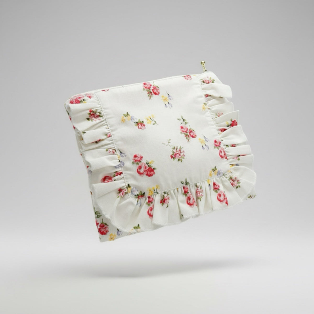 White floral ruffle zipper pouch with gathered ruffle front and brass zipper pull