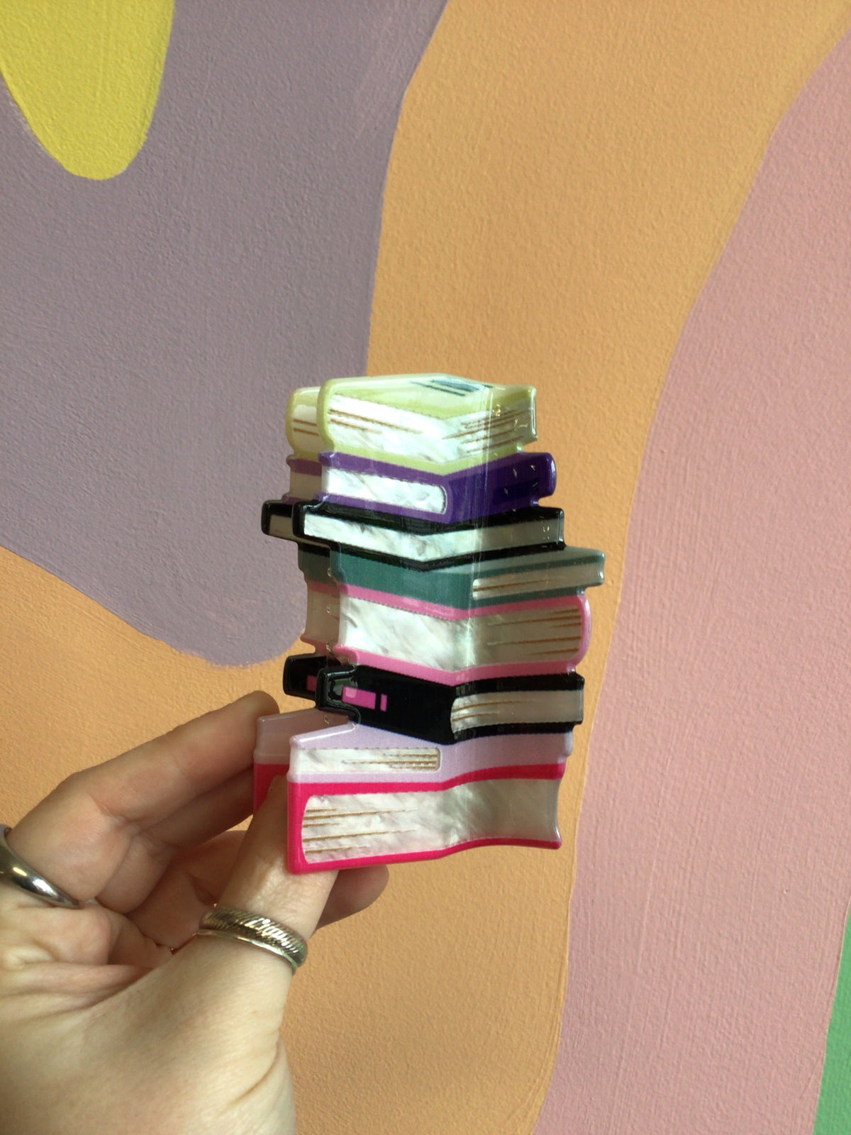Book stack hair claw with mini-book tiers in green, pink, and black