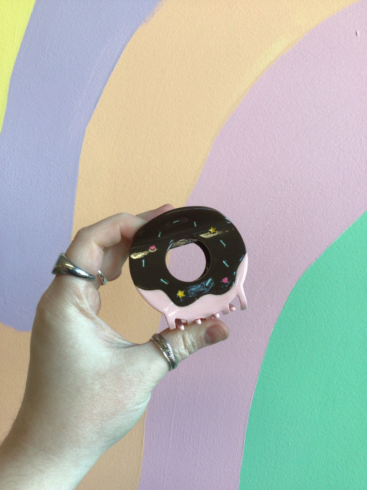 Donut-shaped hair claw with dark frosting and pink center hole