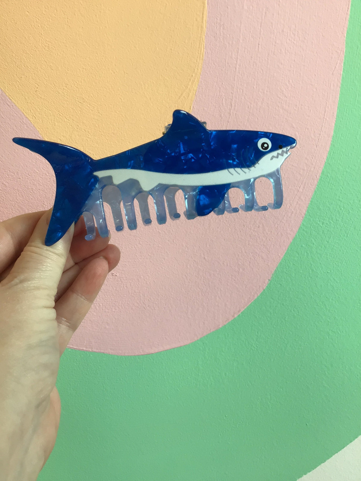 Blue shark-like fish hair claw with translucent ridged comb teeth.
