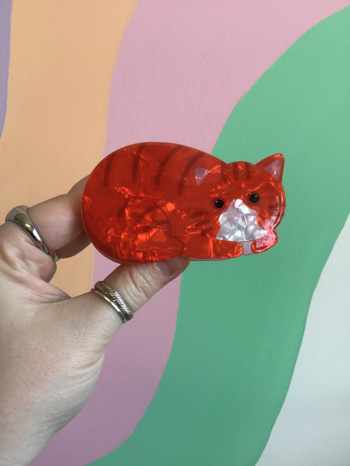 Red translucent cat hair claw with orange eyes and white cheek details