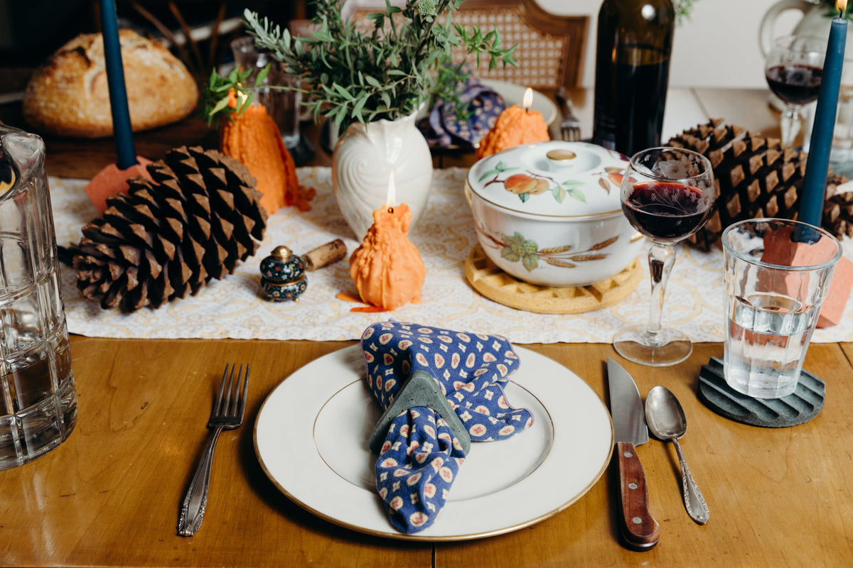 Marigold terrazzo round waffle trivet under a floral teapot on a dining table