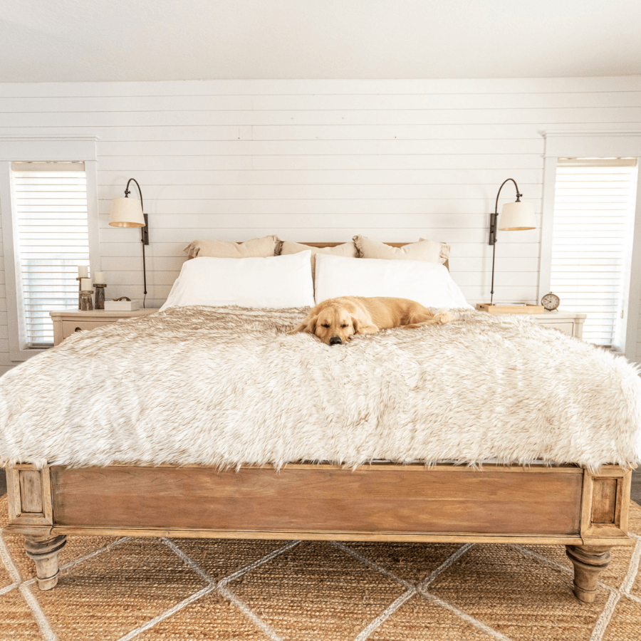 Waterproof shag throw blanket covering bed, off-white textured surface