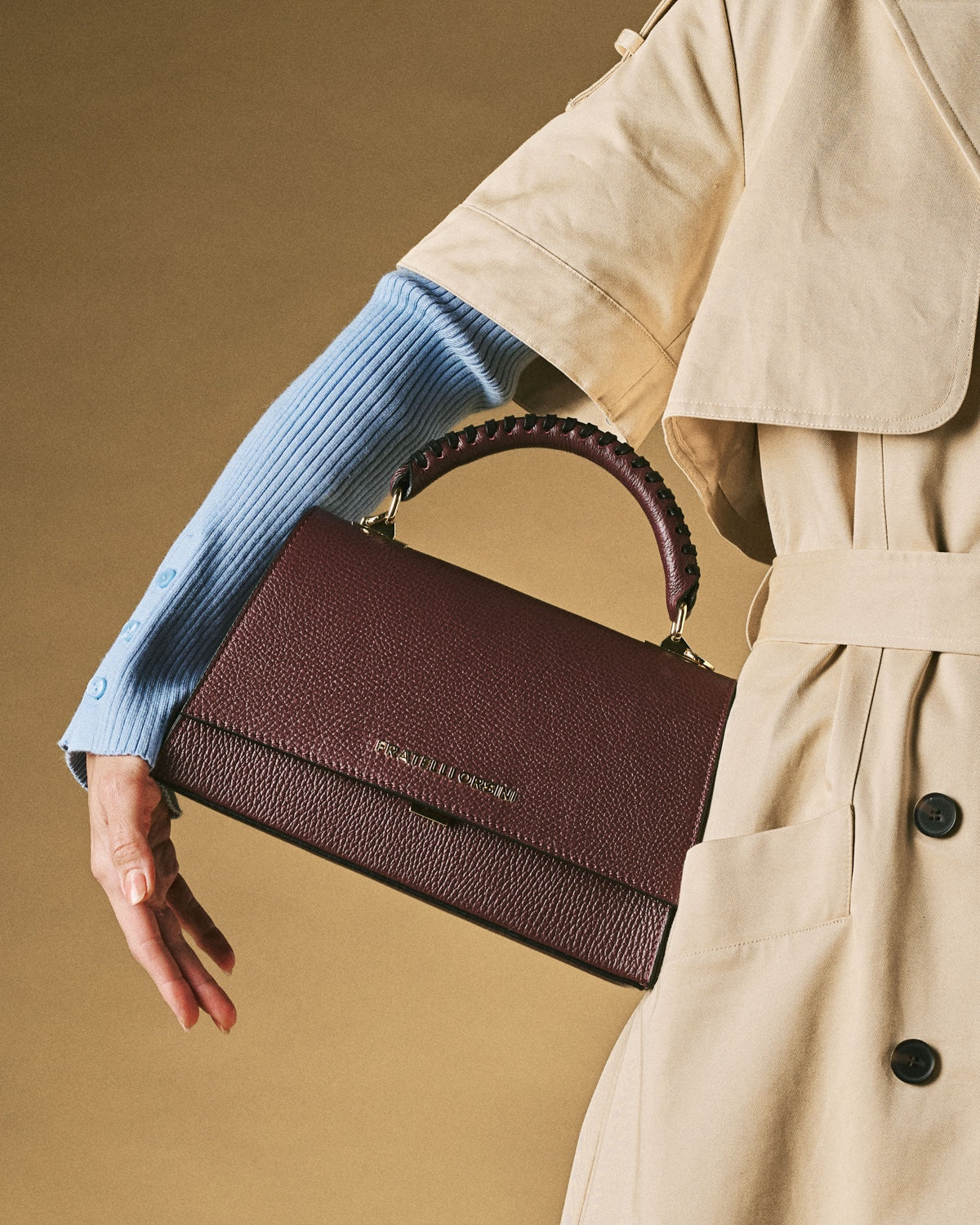 Close view of eggplant leather crossbody bag with braided handle and top flap