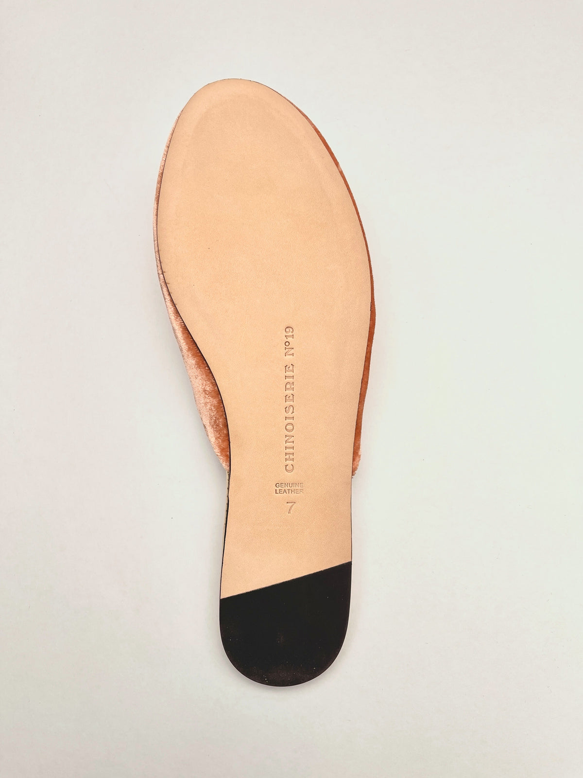 Sole view of peach velvet mule slippers with cream outsole edge