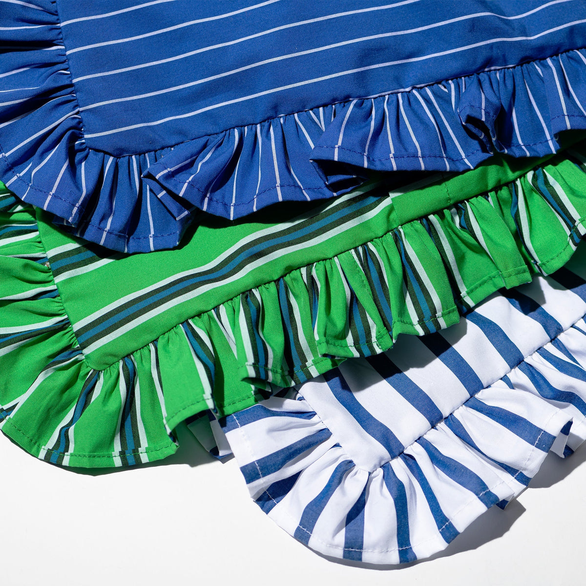 Striped ruffle cushion cover close-up with blue, green, and white gathered trim