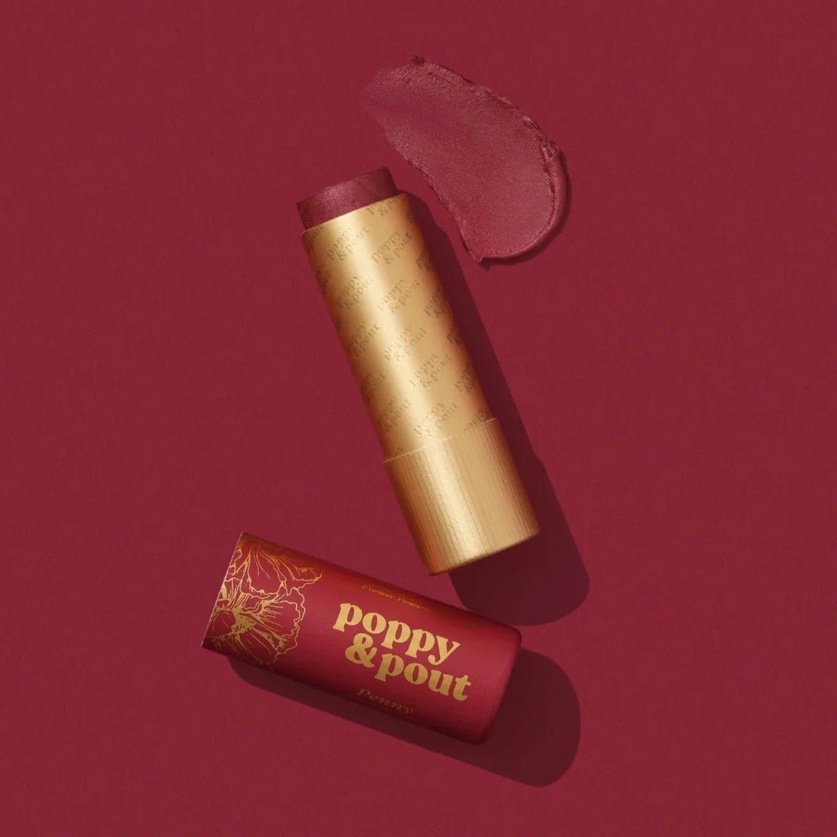 Lip tint tubes with gold caps, red shade product close-up